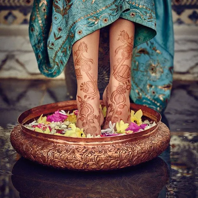 woman soaking her feet in water with flowers in